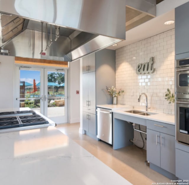 kitchen with stainless steel appliances, gray cabinetry, backsplash, french doors, and sink