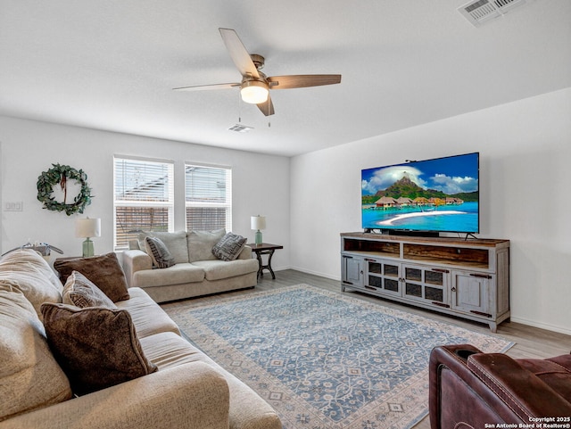 living room with light hardwood / wood-style floors and ceiling fan