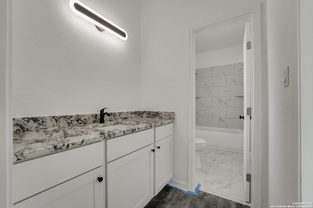 full bathroom with toilet, vanity, and tiled shower / bath combo