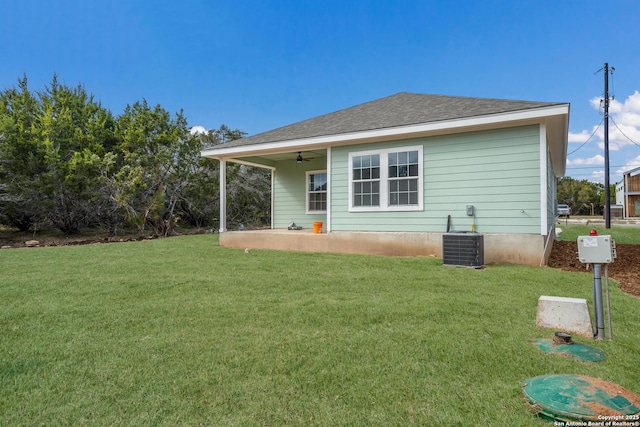 rear view of property with ceiling fan, cooling unit, a lawn, and a patio