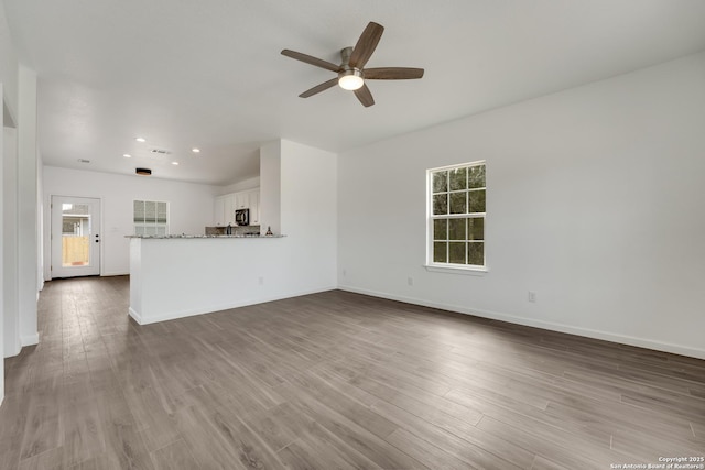 unfurnished living room with hardwood / wood-style flooring, ceiling fan, and plenty of natural light