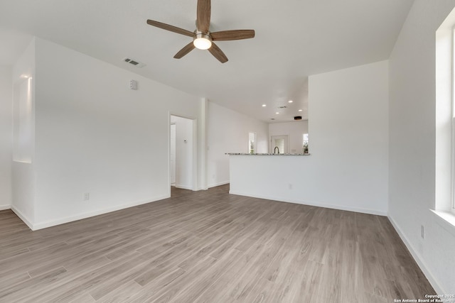 unfurnished living room with ceiling fan and light wood-type flooring