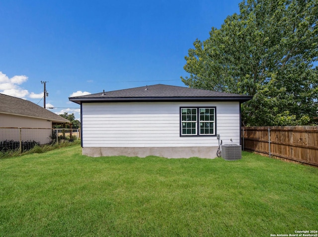 back of house featuring a yard and central AC