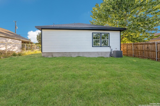 exterior space with central air condition unit and a lawn