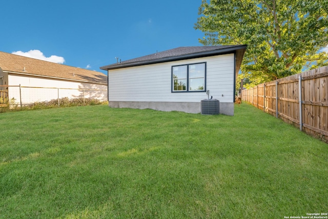 back of house featuring cooling unit and a yard