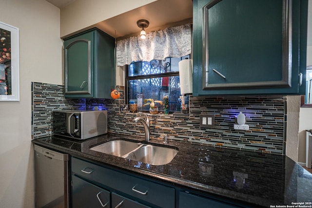 kitchen with backsplash, dishwasher, dark stone countertops, pendant lighting, and sink