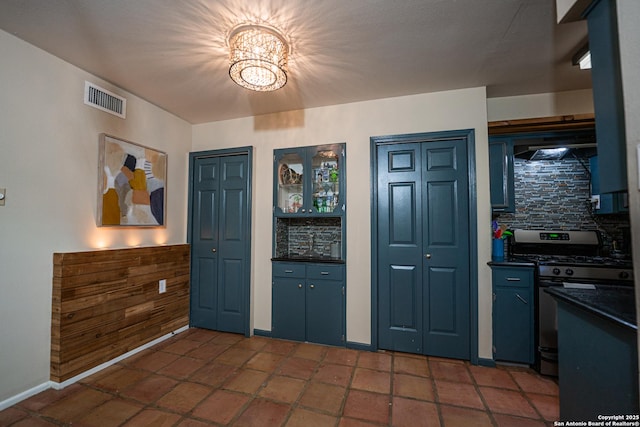 kitchen with a chandelier, gas range, and backsplash