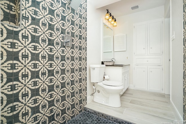 bathroom with toilet, vanity, a shower, and hardwood / wood-style flooring