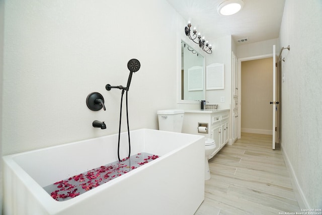 bathroom with toilet, vanity, a bathing tub, and hardwood / wood-style floors