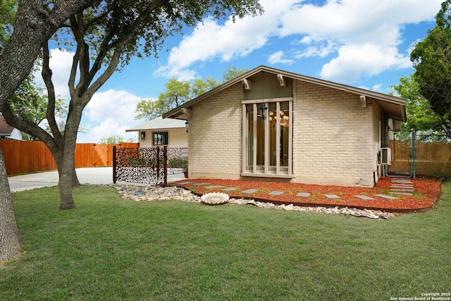 back of house featuring a lawn and cooling unit