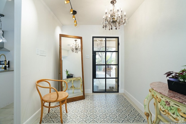 doorway featuring track lighting and a notable chandelier