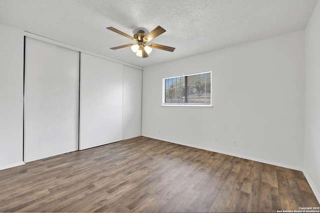 unfurnished bedroom with a textured ceiling, ceiling fan, and dark hardwood / wood-style flooring