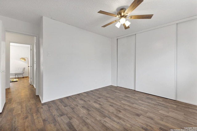 unfurnished room featuring a textured ceiling, ceiling fan, and dark hardwood / wood-style floors