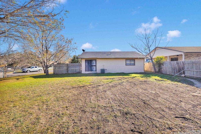 rear view of property with a yard and central AC