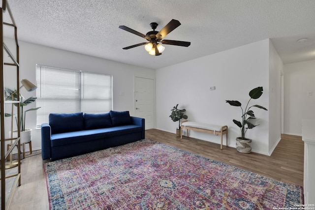 living room featuring a textured ceiling, ceiling fan, and hardwood / wood-style flooring