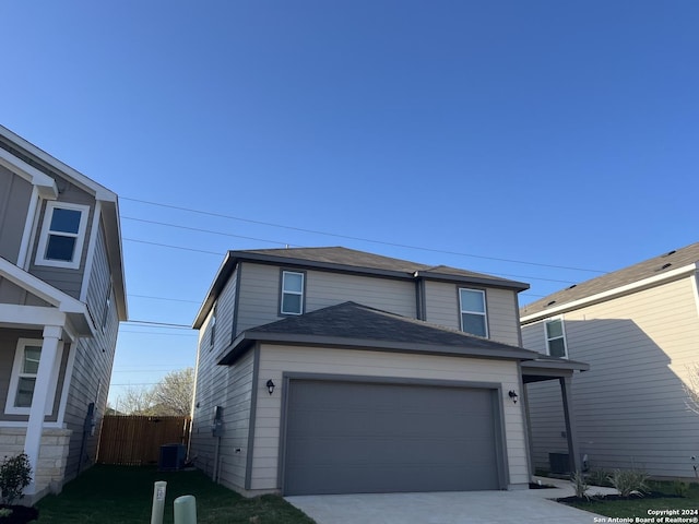 view of property with a garage and central air condition unit