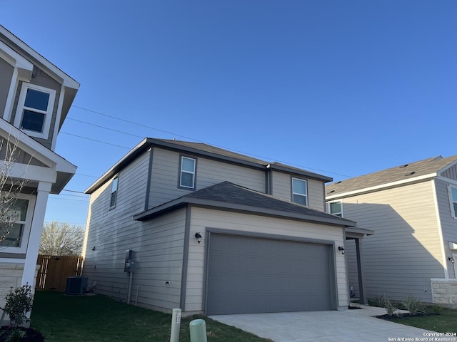 view of front of house with central AC and a garage