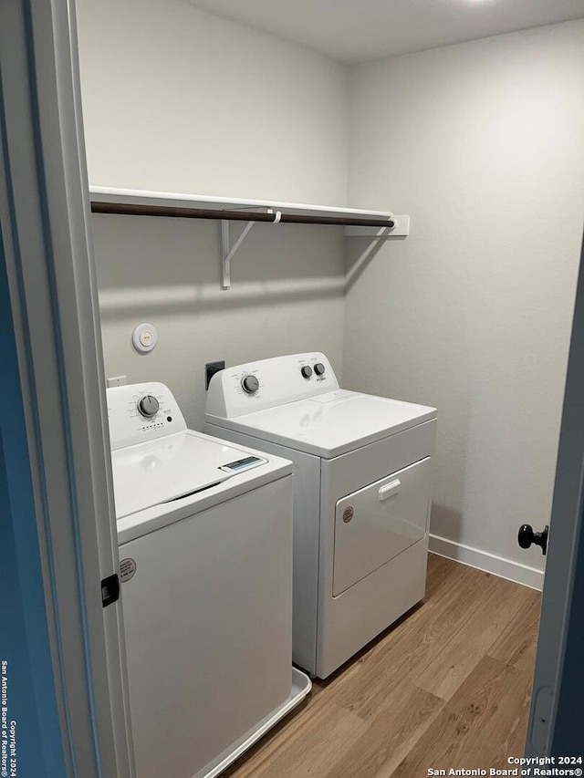 laundry area with light wood-type flooring and separate washer and dryer