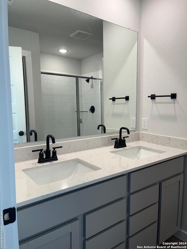 bathroom with vanity and a shower with door