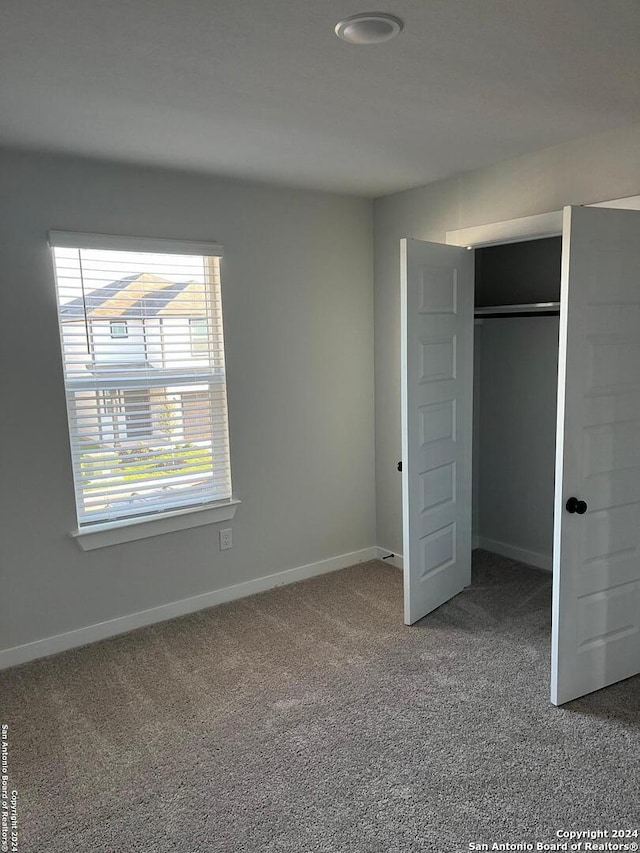 unfurnished bedroom featuring carpet floors and a closet