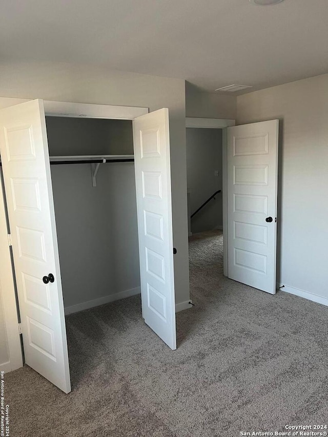 unfurnished bedroom with carpet and a closet