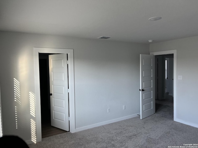 unfurnished bedroom featuring dark carpet