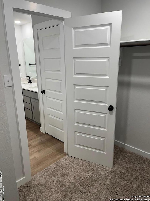 corridor with sink and wood-type flooring