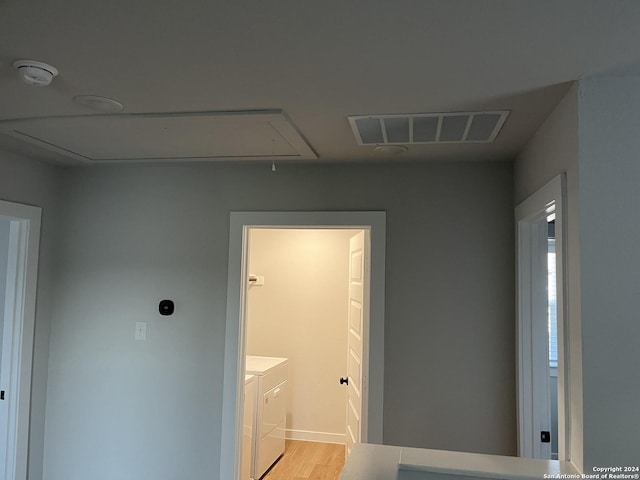 laundry room featuring separate washer and dryer and light hardwood / wood-style flooring