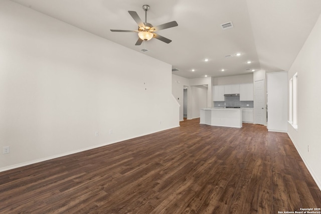 unfurnished living room featuring dark wood-type flooring and ceiling fan