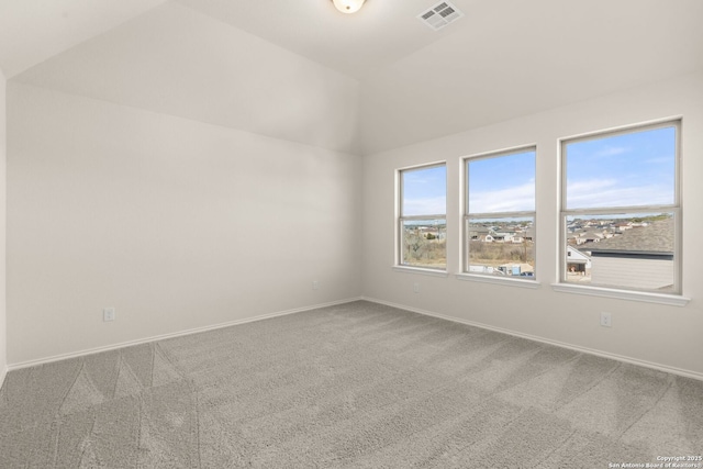 carpeted spare room with vaulted ceiling