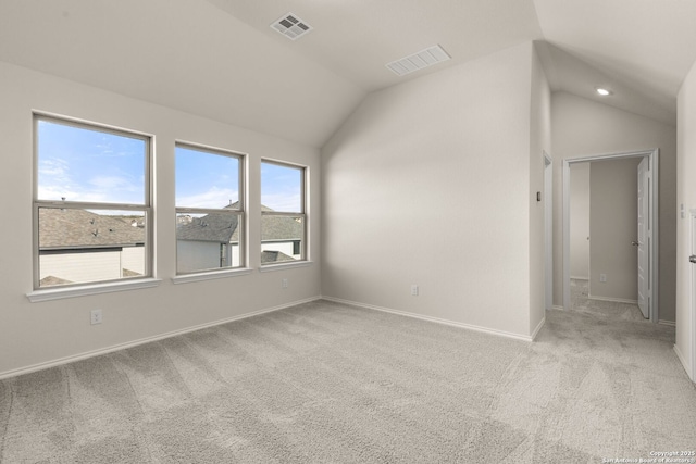 spare room with lofted ceiling and light carpet