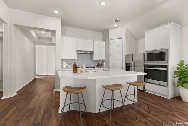 kitchen featuring sink, a breakfast bar area, white cabinetry, appliances with stainless steel finishes, and an island with sink