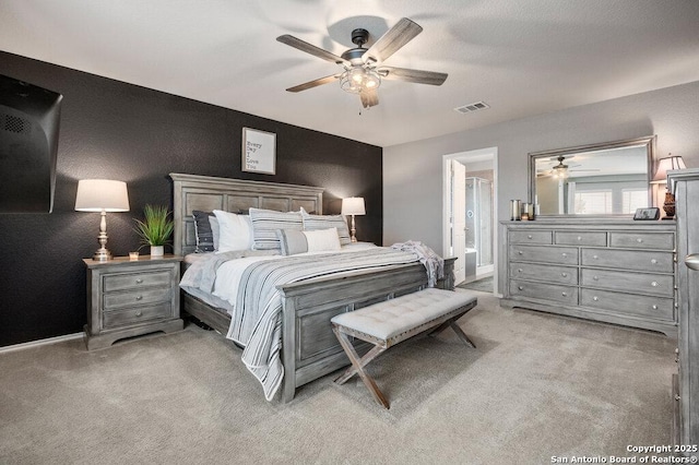 carpeted bedroom with ceiling fan and ensuite bathroom