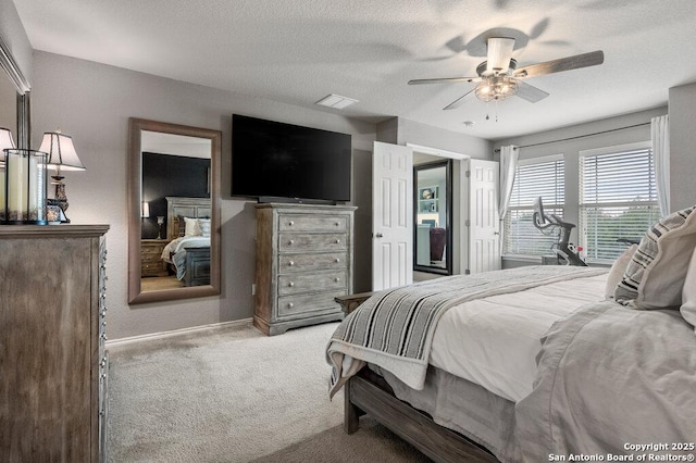 bedroom featuring a textured ceiling, ceiling fan, and light colored carpet