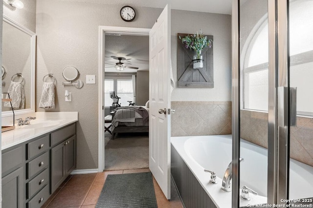 bathroom featuring ceiling fan, vanity, tile patterned flooring, and a bath