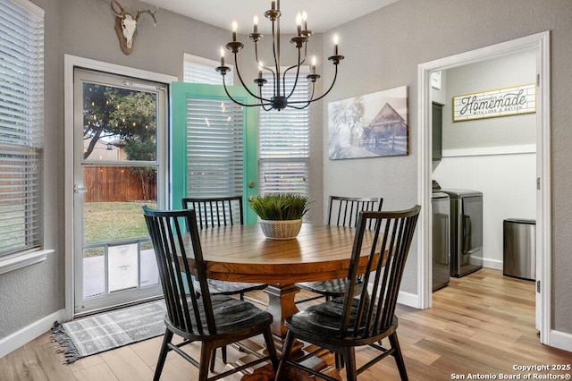 dining space with a chandelier, light hardwood / wood-style floors, and washer and clothes dryer