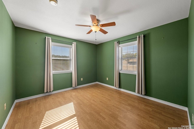 spare room with hardwood / wood-style flooring and ceiling fan