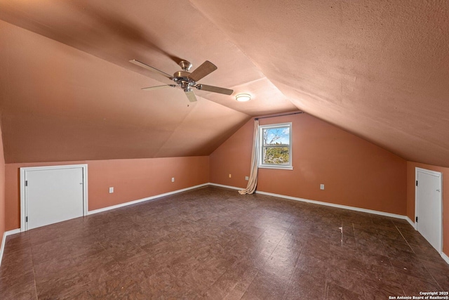 additional living space with a textured ceiling, ceiling fan, and lofted ceiling