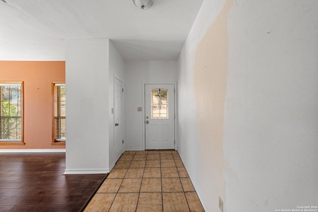 doorway to outside with dark tile patterned floors