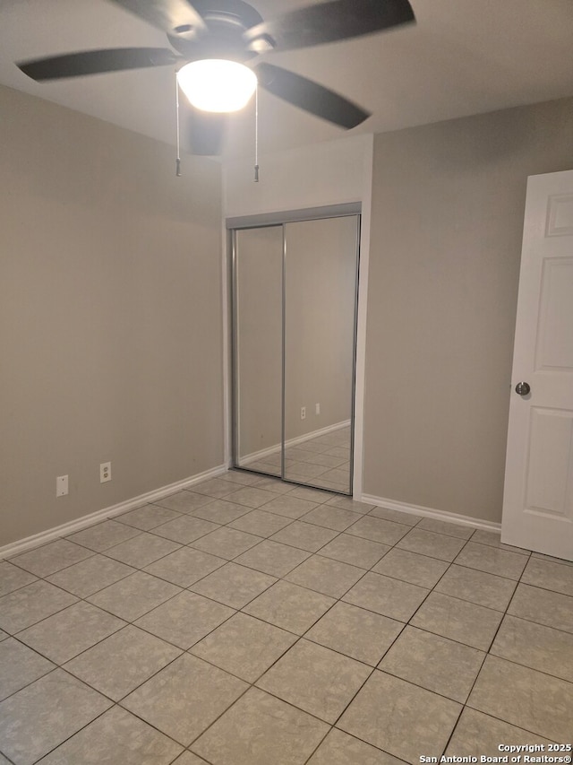 unfurnished bedroom with ceiling fan, light tile patterned floors, and a closet