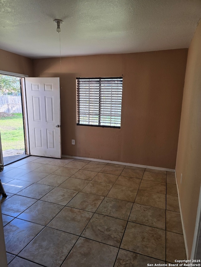 entryway with a textured ceiling and tile patterned flooring