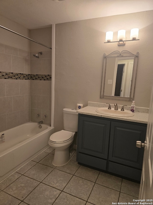 full bathroom with toilet, tiled shower / bath combo, tile patterned floors, and vanity