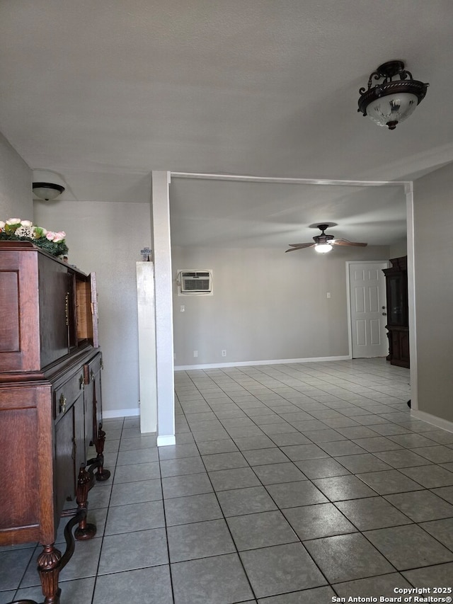 unfurnished living room featuring ceiling fan, tile patterned floors, and a wall unit AC