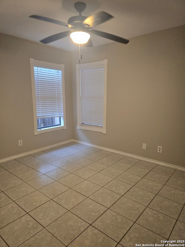 tiled empty room featuring ceiling fan