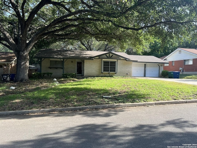 ranch-style house featuring a front yard and a garage