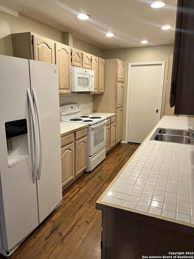 kitchen with white appliances, light brown cabinets, sink, backsplash, and dark hardwood / wood-style floors