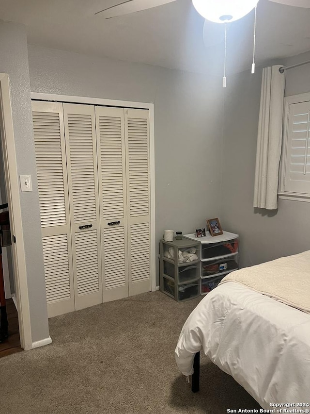 carpeted bedroom with ceiling fan and a closet