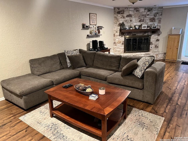 living room featuring ceiling fan, hardwood / wood-style floors, crown molding, and a fireplace