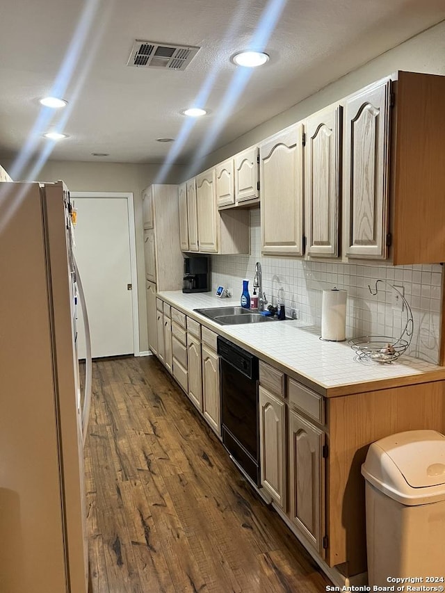 kitchen featuring dishwasher, decorative backsplash, sink, dark hardwood / wood-style floors, and fridge