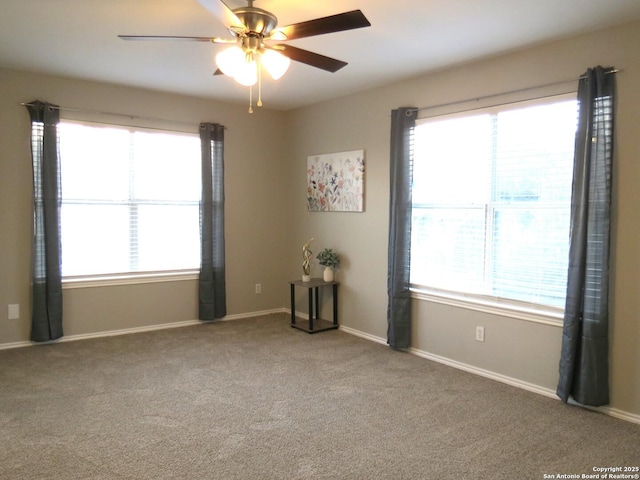 empty room with ceiling fan, plenty of natural light, and carpet flooring